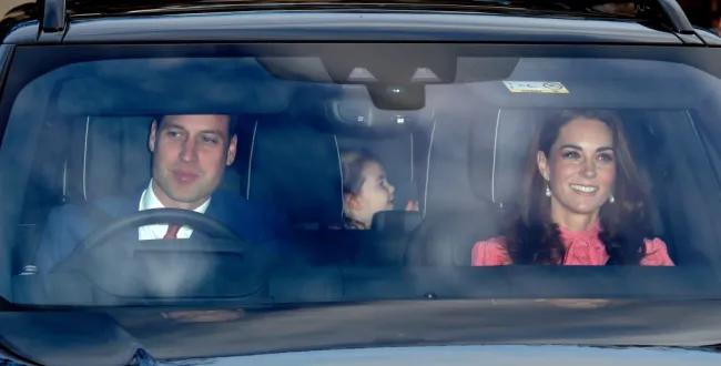 El príncipe Guillermo conduciendo un coche con Made Middleton y Charlotte en la parte de atrás.
