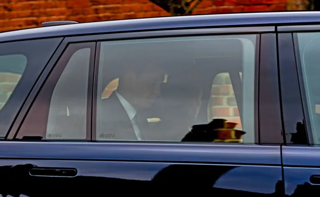 La princesa Kate y el príncipe William vistos a través de la ventanilla de un automóvil, mirando en direcciones opuestas