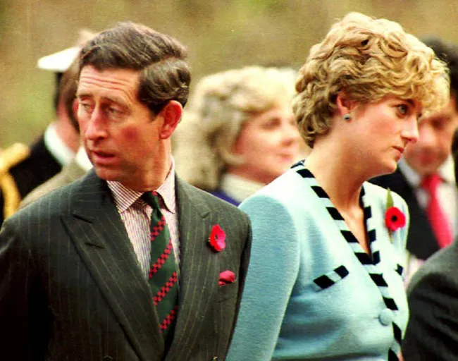 El rey Carlos y la princesa Diana apartan la mirada el uno del otro.