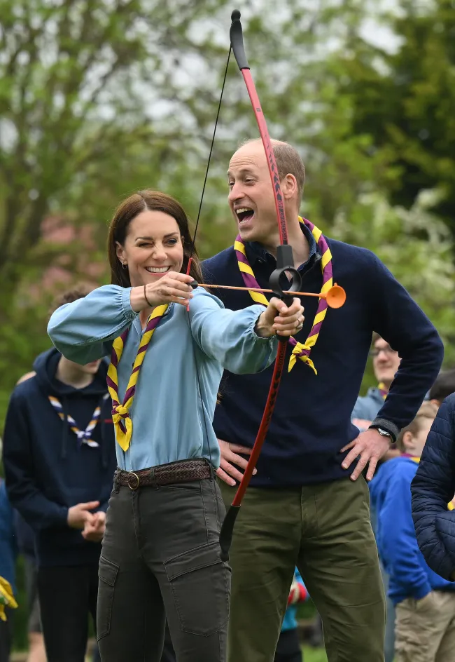 Kate Middleton sosteniendo un arco y una flecha junto al Príncipe Guillermo.