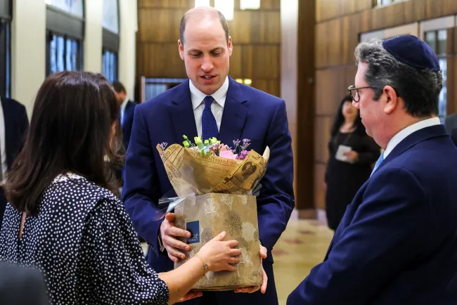 El Príncipe William aceptando flores.