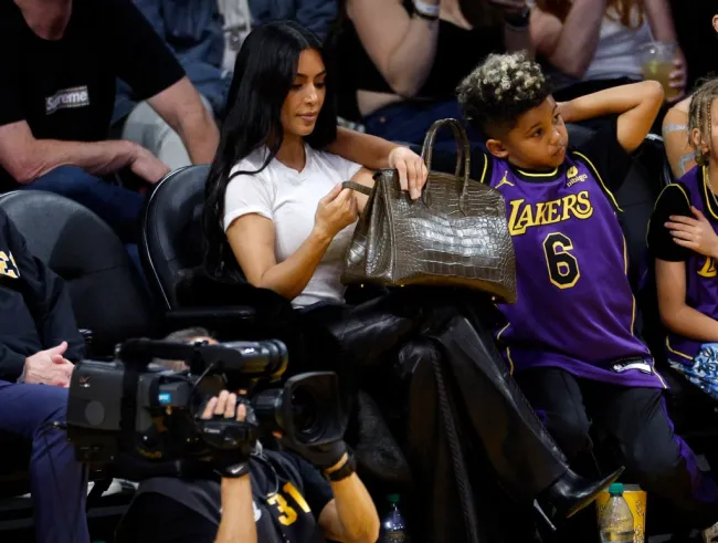 Kim Kardashian deja el bolso Birkin en el suelo mientras asiste al partido de los Lakers con su hijo Saint West