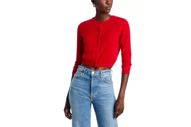 Un modelo con una rebeca roja y jeans.