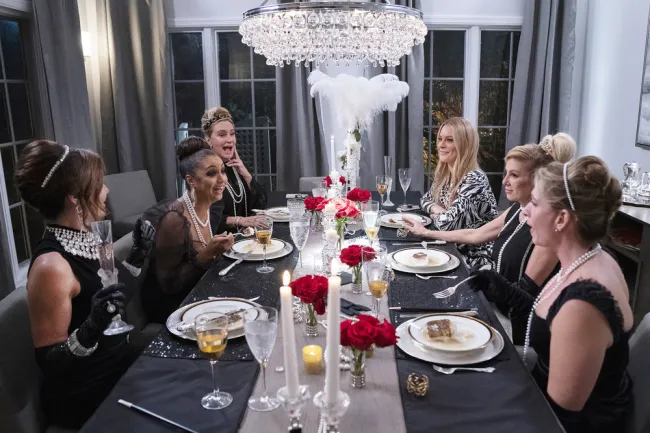 Luann de Lesseps, Eboni K. Williams, Sonja Morgan, Leah McSweeney, Ramona Singer y Heather Thomson sentadas juntas durante la cena.