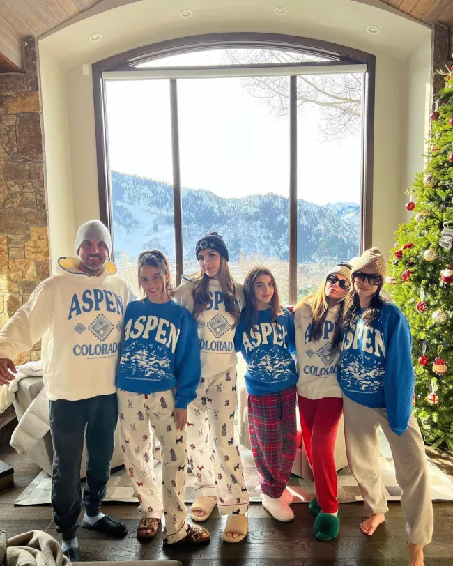 Kyle Richards posando con sus cuatro hijas y Mauricio Umansky con sudaderas de Aspen a juego frente a una vista de la montaña.