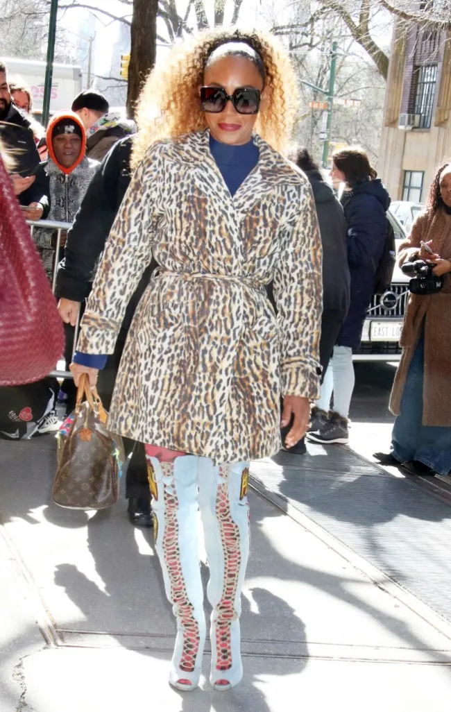 Mel B recorrió las calles de Nueva York con una gabardina con estampado de leopardo y pantalones blancos multicolores. Completó el look con grandes gafas de sol y el pelo recogido en una coleta alta.