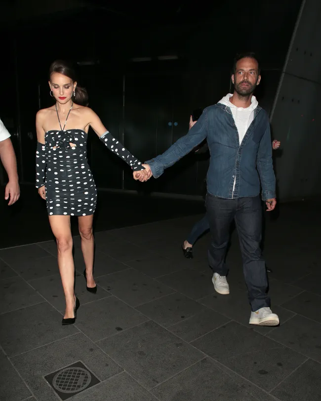 Natalie Portman y Benjamin Millepied tomados de la mano mientras se separan.
