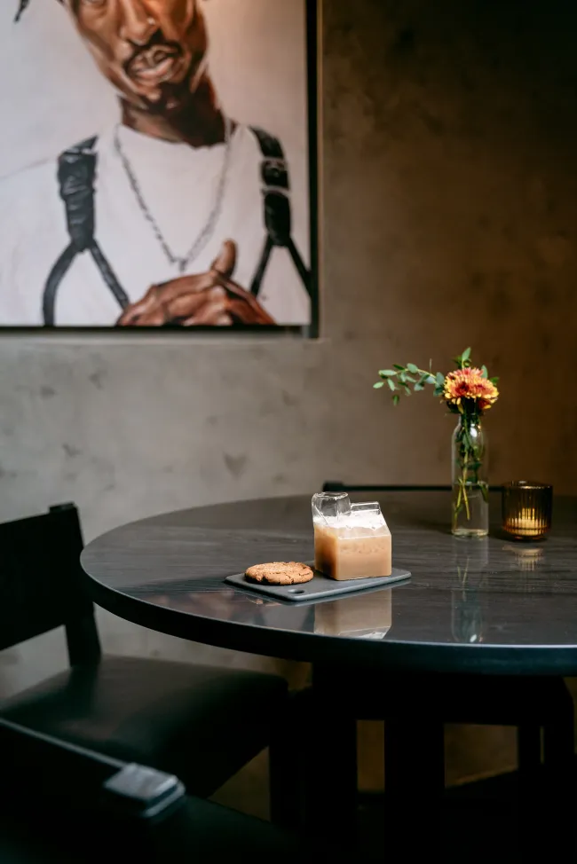 Una mesa de esquina con un retrato de Tupac colgando encima.