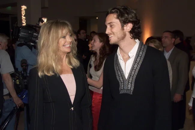 Goldie Hawn y Oliver Hudson sonriéndose el uno al otro