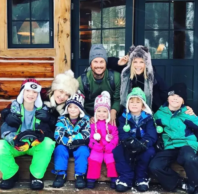 Oliver Hudson y su esposa, Kate Hudson y un grupo de niños sentados en una entrada.