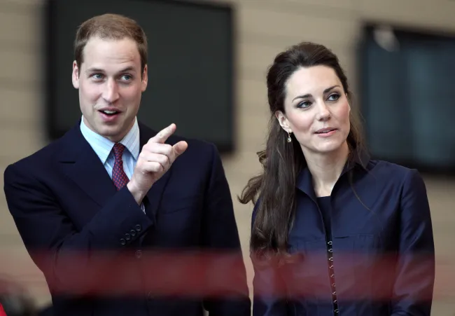 Kate Middleton y el Príncipe William señalando.