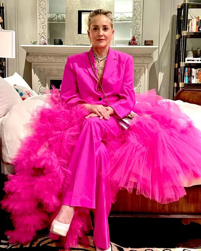 Sharon Stone con un traje pantalón rosa intenso con volantes