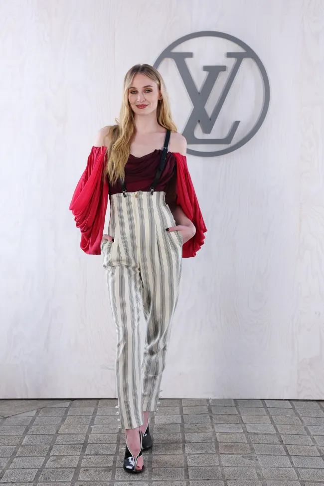 Sophie Turner parada frente al logo de LV