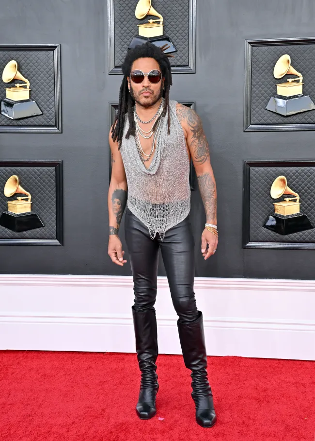 Lenny Kravitz con top con cadenas plateadas y pantalones pitillo de cuero en los Premios Grammy 2022.