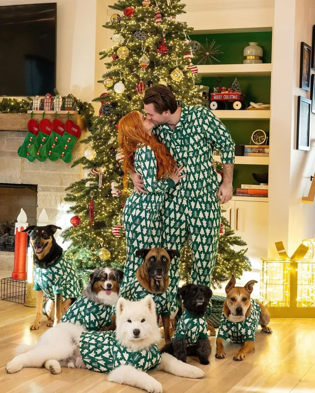Ariel Winter, Luke Benward y sus perros en pijamas a juego frente a un árbol de Navidad