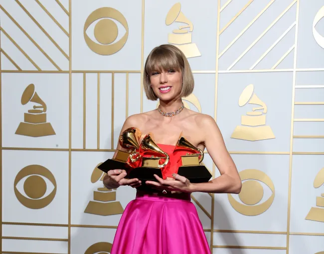 Taylor Swift sosteniendo sus premios Grammy.
