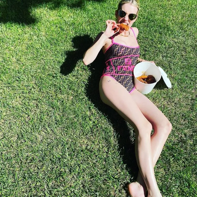 Emma Roberts comiendo pollo frito en su jardín.