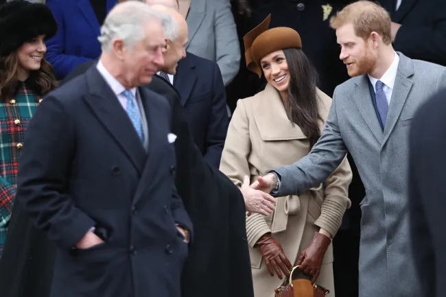 El rey Carlos, Meghan Markle y el príncipe Harry de pie