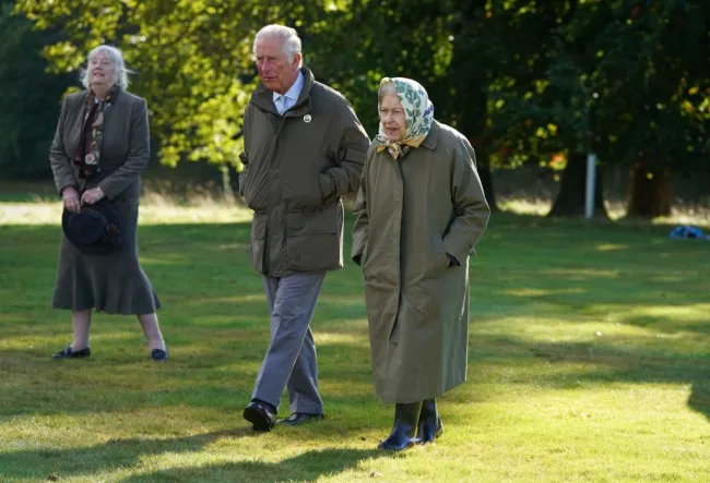 La reina Isabel II y el rey Carlos caminan por los terrenos de Balmoral en octubre de 2021.