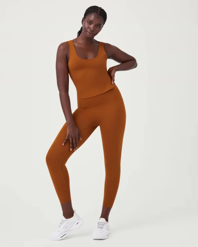 Un modelo con leggings naranjas y una camiseta sin mangas.