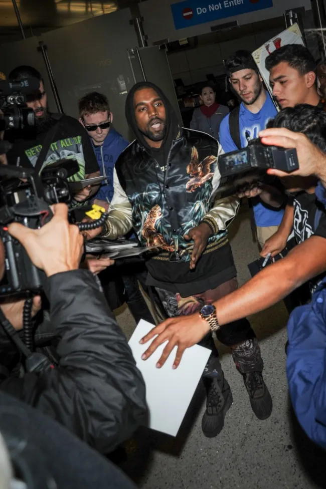 Kanye West peleando con paparazzi.
