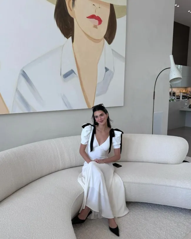 Kendall Jenner sentada en un sofá con un vestido de seda blanco en Semana Santa.
