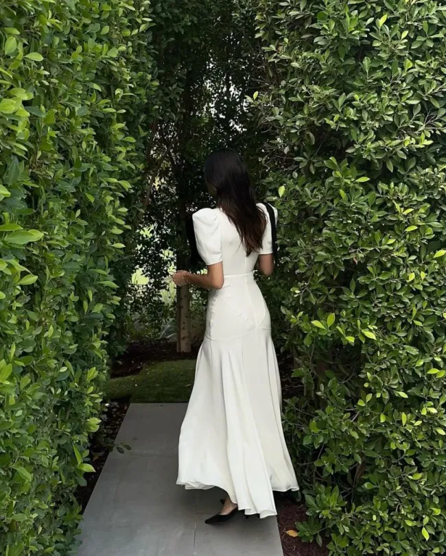 Kendall Jenner con vestido de seda blanco de espaldas a la cámara.