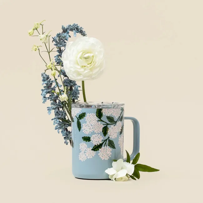 Una taza de café rodeada de flores.