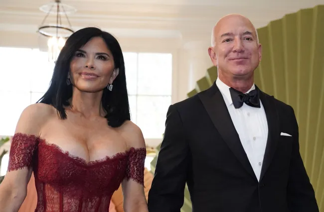 Jeff Bezos y Lauren Sanchez sonríen al llegar a la Casa Blanca.