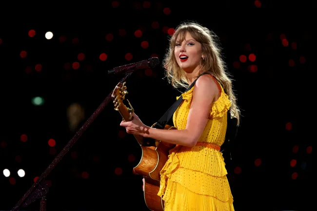Taylor Swift actuando con un vestido amarillo.