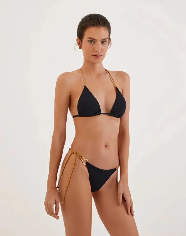 Una modelo en bikini negro con espalda en T.
