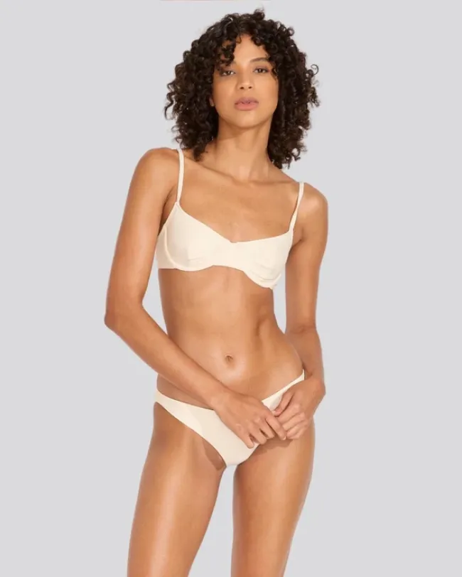 Una modelo en bikini color crema.