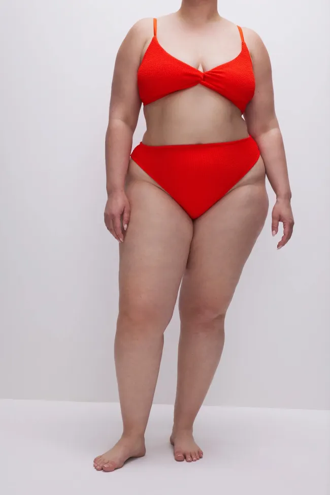 Una modelo en bikini rojo de cintura alta.