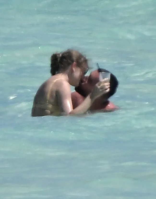 Taylor Swift y Travis Kelce besándose en el océano