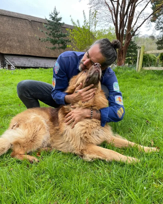 Russell Brand abrazando a un perro