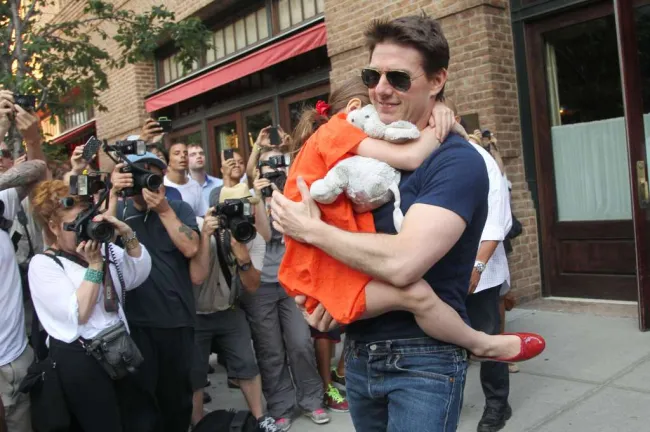 Tom Cruise sostiene a Suri Cruise cuando salen de su clase de gimnasia en Nueva York en julio de 2012.