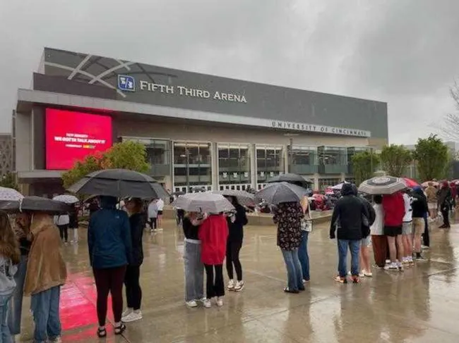 Fanáticos haciendo fila afuera de Fifth Third Arena bajo la lluvia.