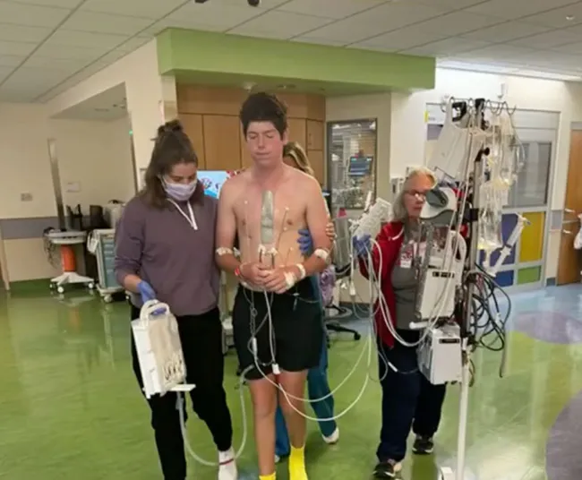 Paul Baier caminando con enfermeras en el hospital.