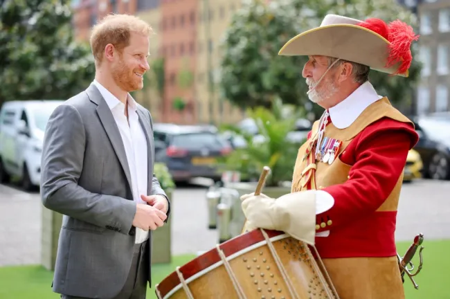 El Príncipe Harry sonríe mientras se reúne con piqueros y mosqueteros.
