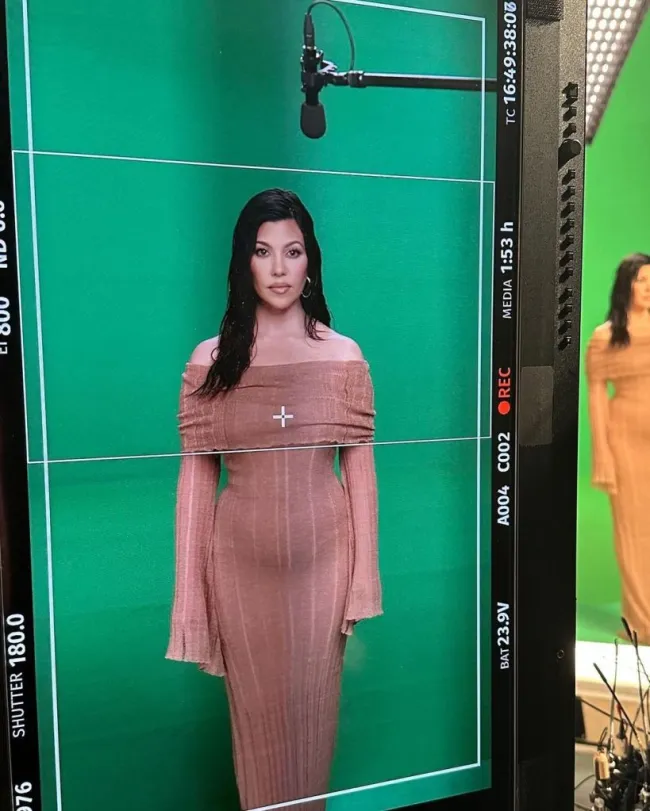 Kourtney Kardashian parada frente a una pantalla verde.