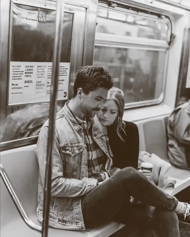 Tyler Stanaland y Brittany Snow sentados juntos en el metro.