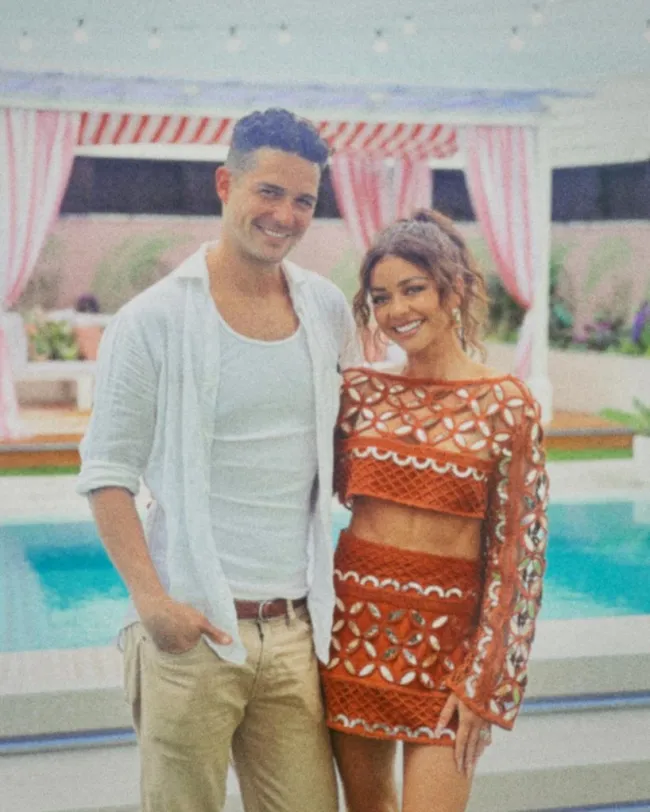 Sarah Hyland y Wells Adams cerca de la piscina.